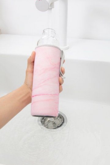 Skleněná láhev s růžovým obalem Skleněná láhev s růžovým obalem